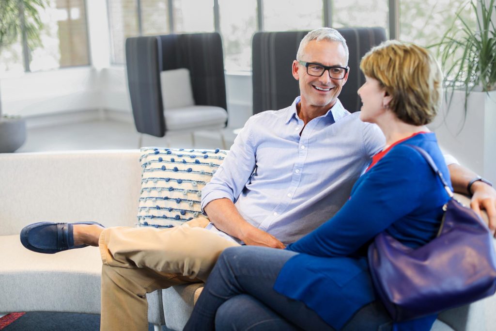 Senior couple sitting on couch conversing